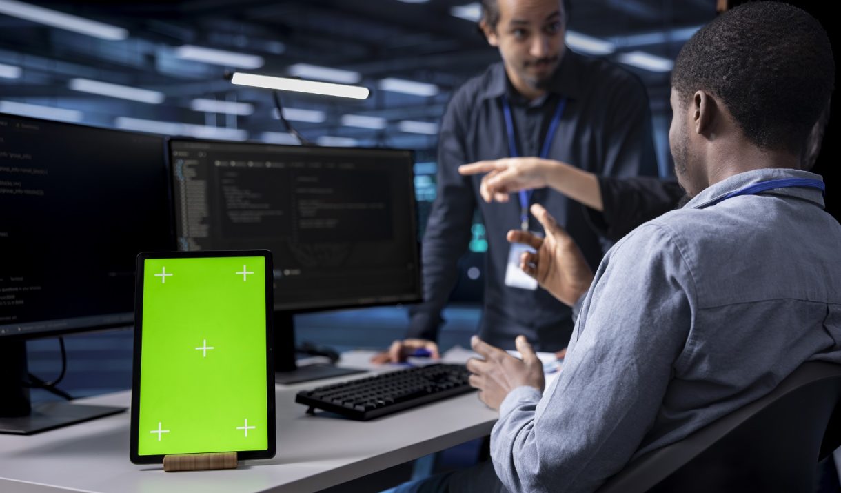 multiethnic team using green screen tablet to oversee servers